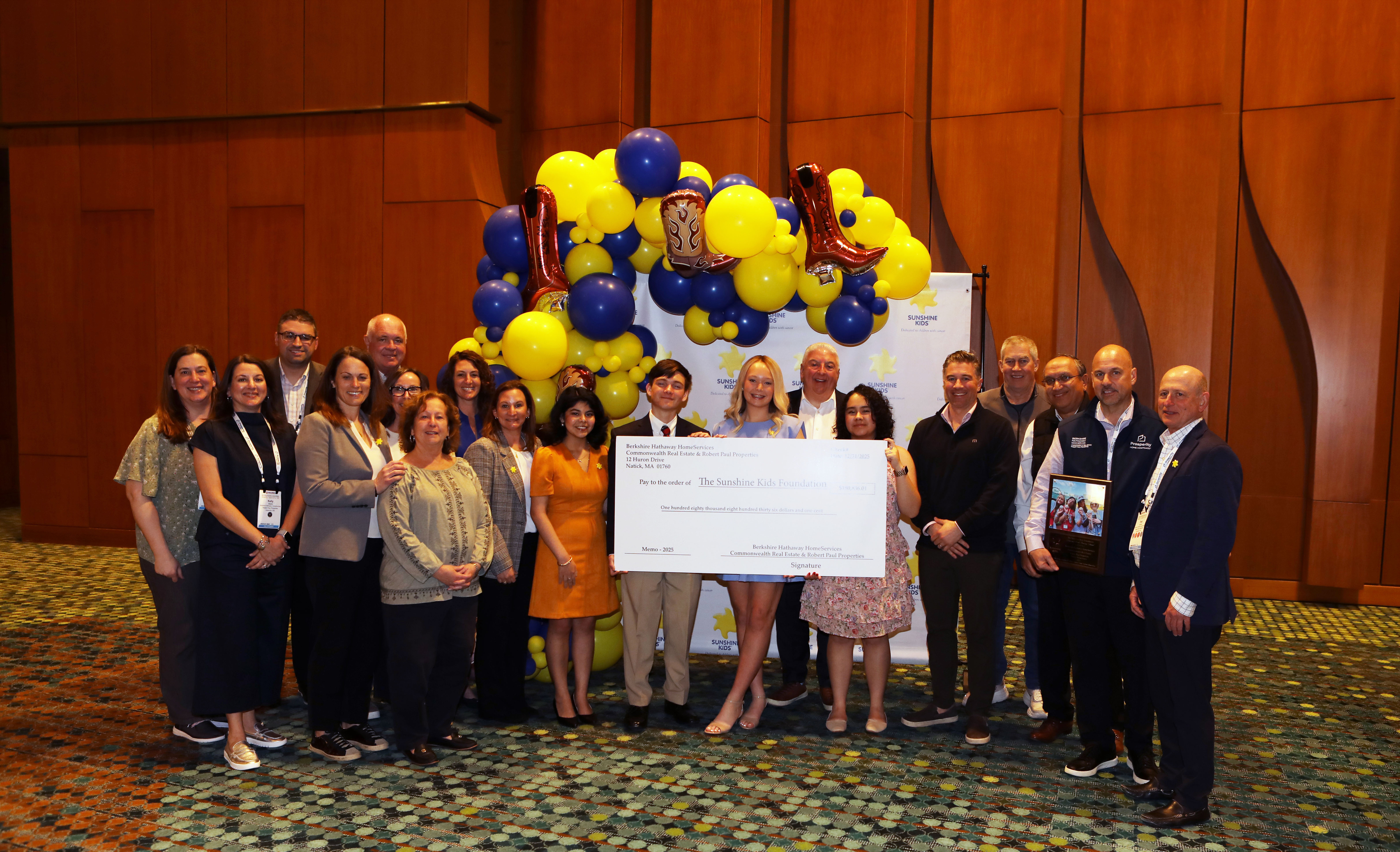 Commonwealth Real Estate and Robert Paul Properties team holding enlarged check made out to Sunshine Kids